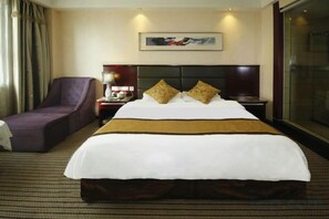 A hotel room with a large bed, a chair, a nightstand, and a window. - Huadong Hotel (Qitaihe (Xinjiang))
