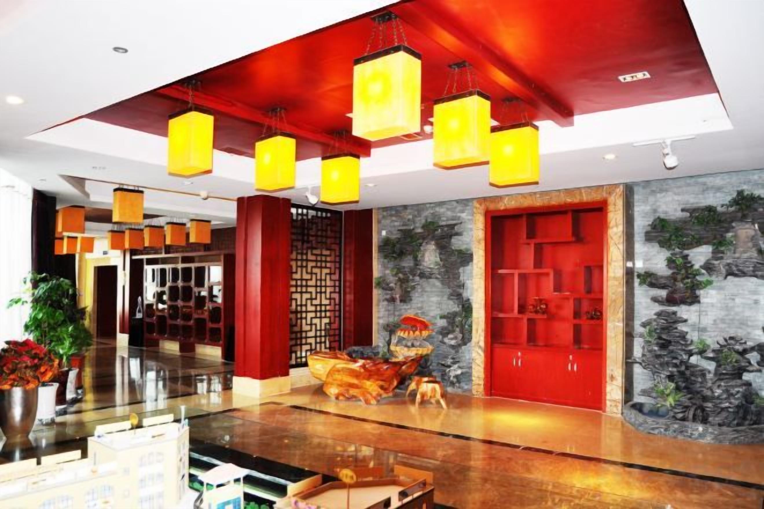 A hotel lobby with a modern design, featuring a reception desk, seating area, and decorative elements like plants and artwork.