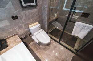 A modern bathroom with a toilet, shower, and bathtub.