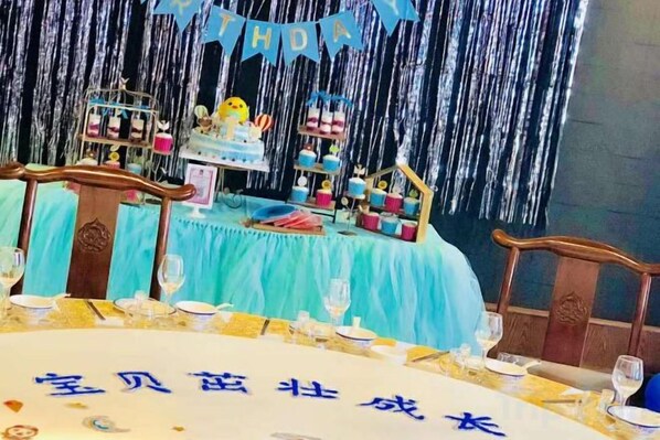 Ein festlich gedeckter Tisch mit einem Geburtstagswimpel, einer Torte und verschiedenen Partyartikeln.