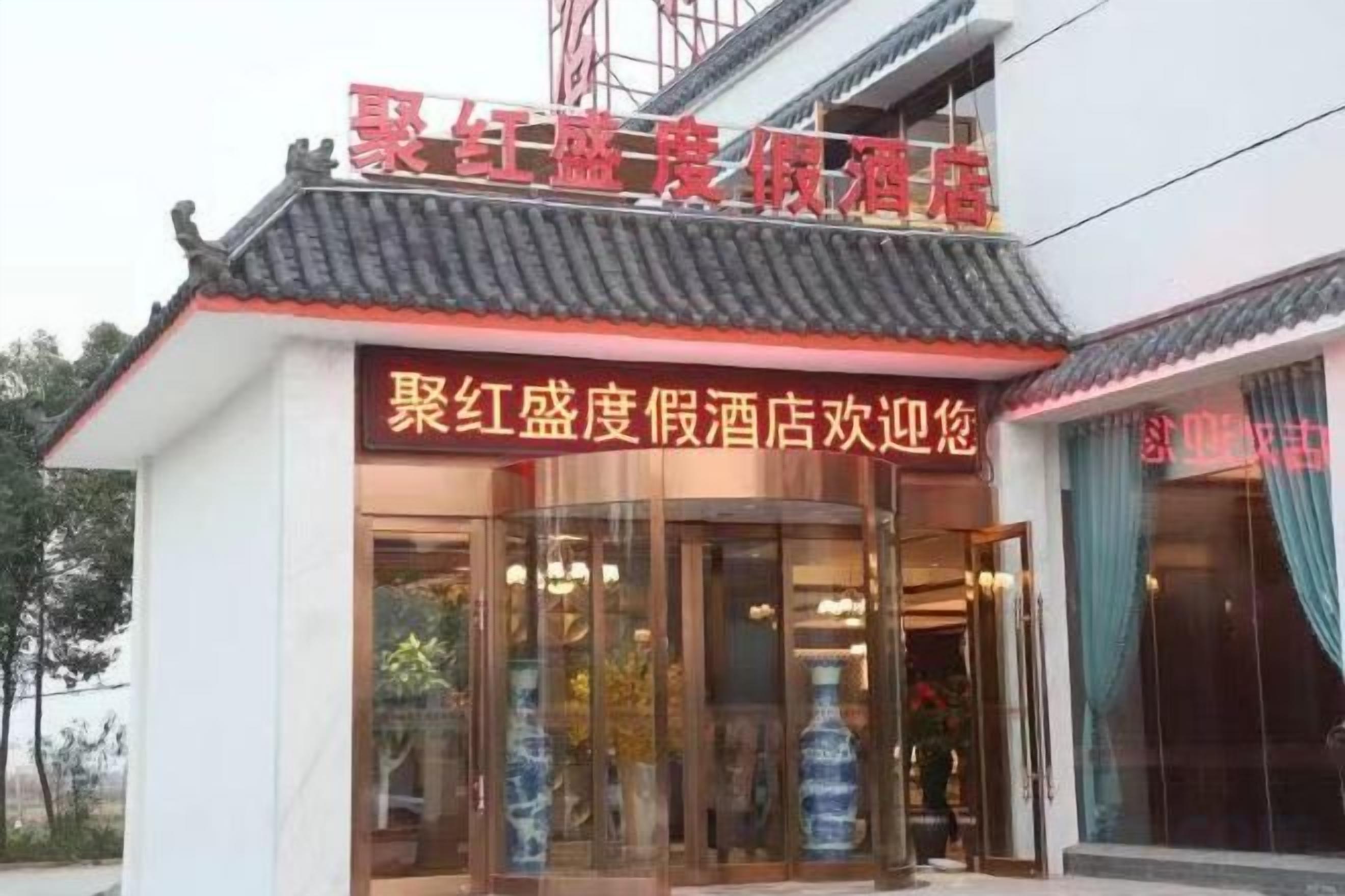 A building with a traditional Chinese architectural style, featuring a tiled roof and a signboard with Chinese characters.