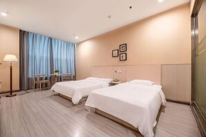 A hotel room with two beds, a desk, a chair, a lamp, and a window with curtains. - Binle Business Express Hotel (Shijiazhuang)
