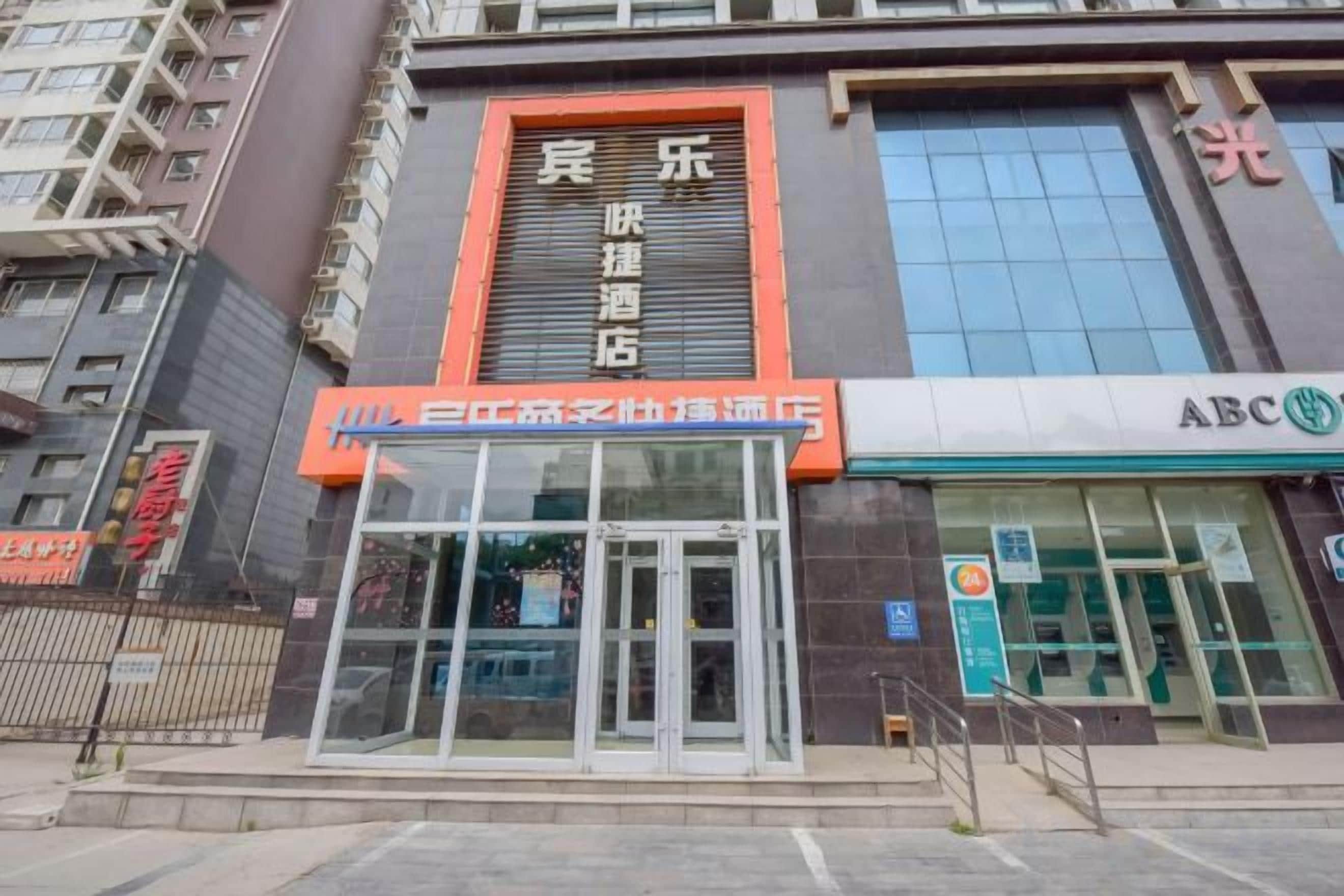 A hotel with a prominent entrance, a large window, and a sign for ABC.