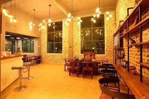A restaurant with brick walls, hanging lights, and a bar area.