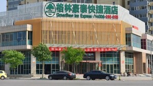 A hotel with a modern facade, featuring a prominent logo and signage. - Greentree INN Beijing Chaoyang District Second FOR (Beijing)