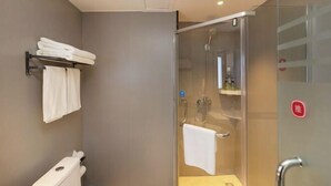 A modern bathroom with a glass shower enclosure, a towel rack, and a toilet.