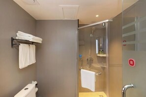 A modern bathroom with a glass shower enclosure, a towel rack, and a toilet.