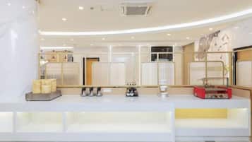 A hotel reception desk with a modern design, featuring a counter, seating area, and a decorative wall.