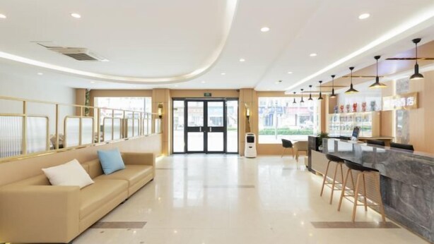 Un lobby moderno de hotel con recepción, bar y área de descanso.