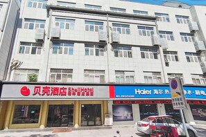 Un hotel de varios pisos, con entrada visible y un cartel.