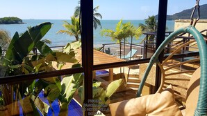 A view from a hotel room overlooking a beach with palm trees and a small island. - Hotel Villa do Mar (Balneário Camboriú)