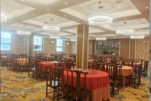 A banquet hall with round tables, chandeliers, and a carpeted floor. - Xinji Holiday Hotel (Nanchang)