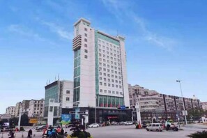 Un hotel de varios pisos con una torre central destacada, rodeado por otros edificios.