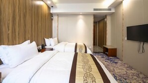 A hotel room with a large bed, a TV mounted on the wall, and a patterned carpet. - Xinji Holiday Hotel (Nanchang)