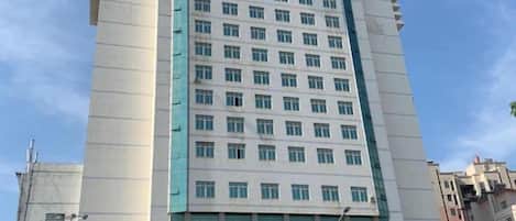 Un edificio de varios pisos con una entrada destacada y señalización.