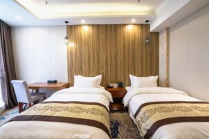 Quarto de hotel com duas camas, uma escrivaninha e uma cadeira.