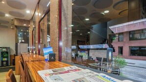 A hotel lobby with a reception desk, seating area, and a view of the street outside. - Hotel del Mar (Vigo)