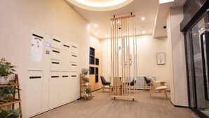 A hallway with lockers, a seating area, and a glass door.
