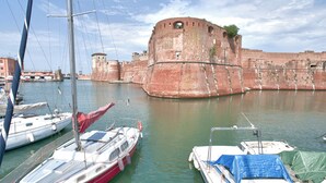 Een historisch fort, omringd door rustig water, met enkele boten afgemeerd in de buurt.