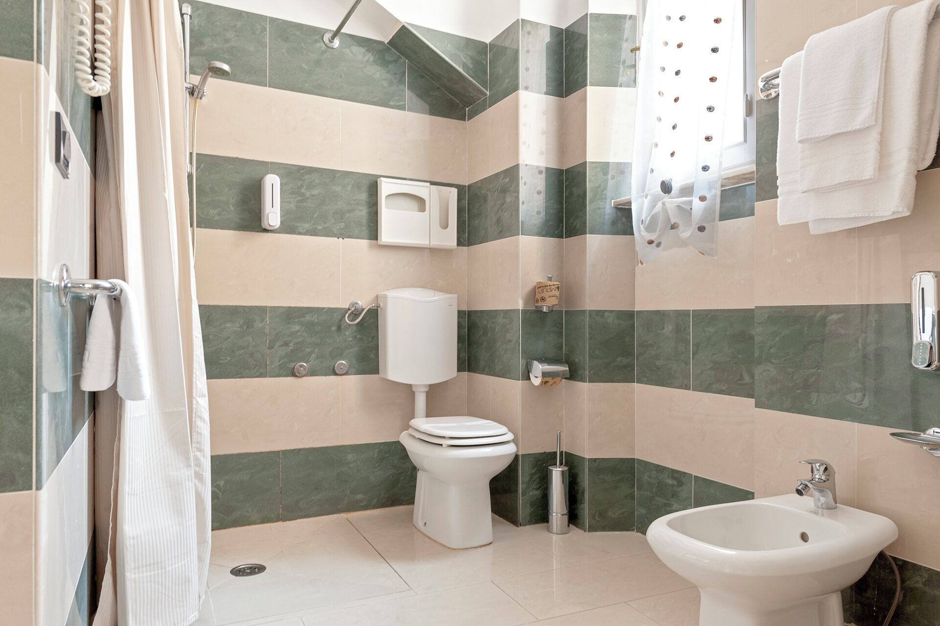 Une salle de bain moderne équipée de toilettes, d’un bidet et d’un espace douche.