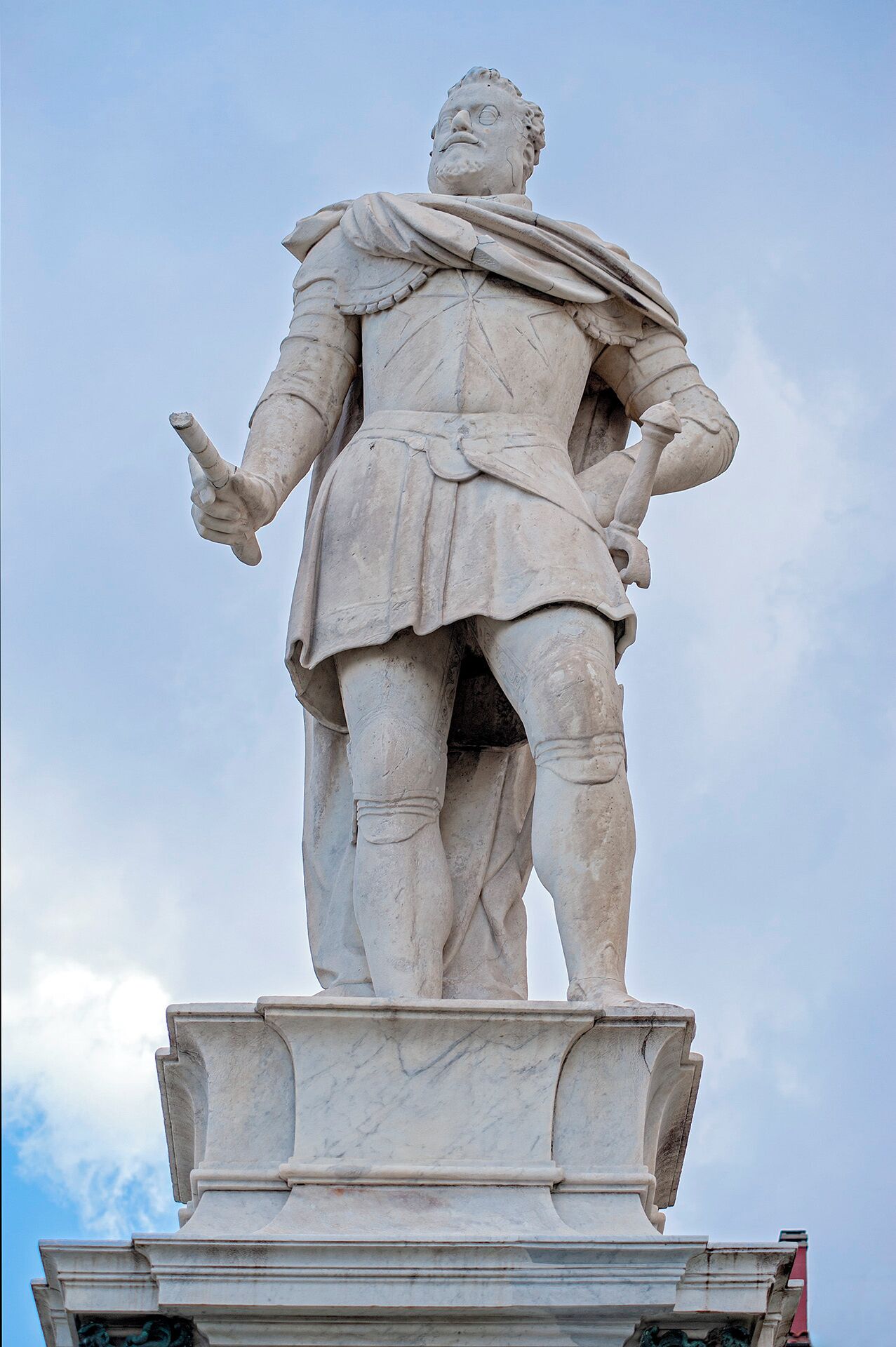 Una estatua de mármol de una figura histórica sobre un pedestal.