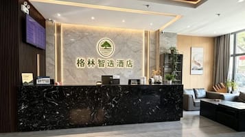 Ein Hotel-Empfangsbereich mit Marmorzauber, einem Logo und einer Sitzecke mit Sofa und Tisch.