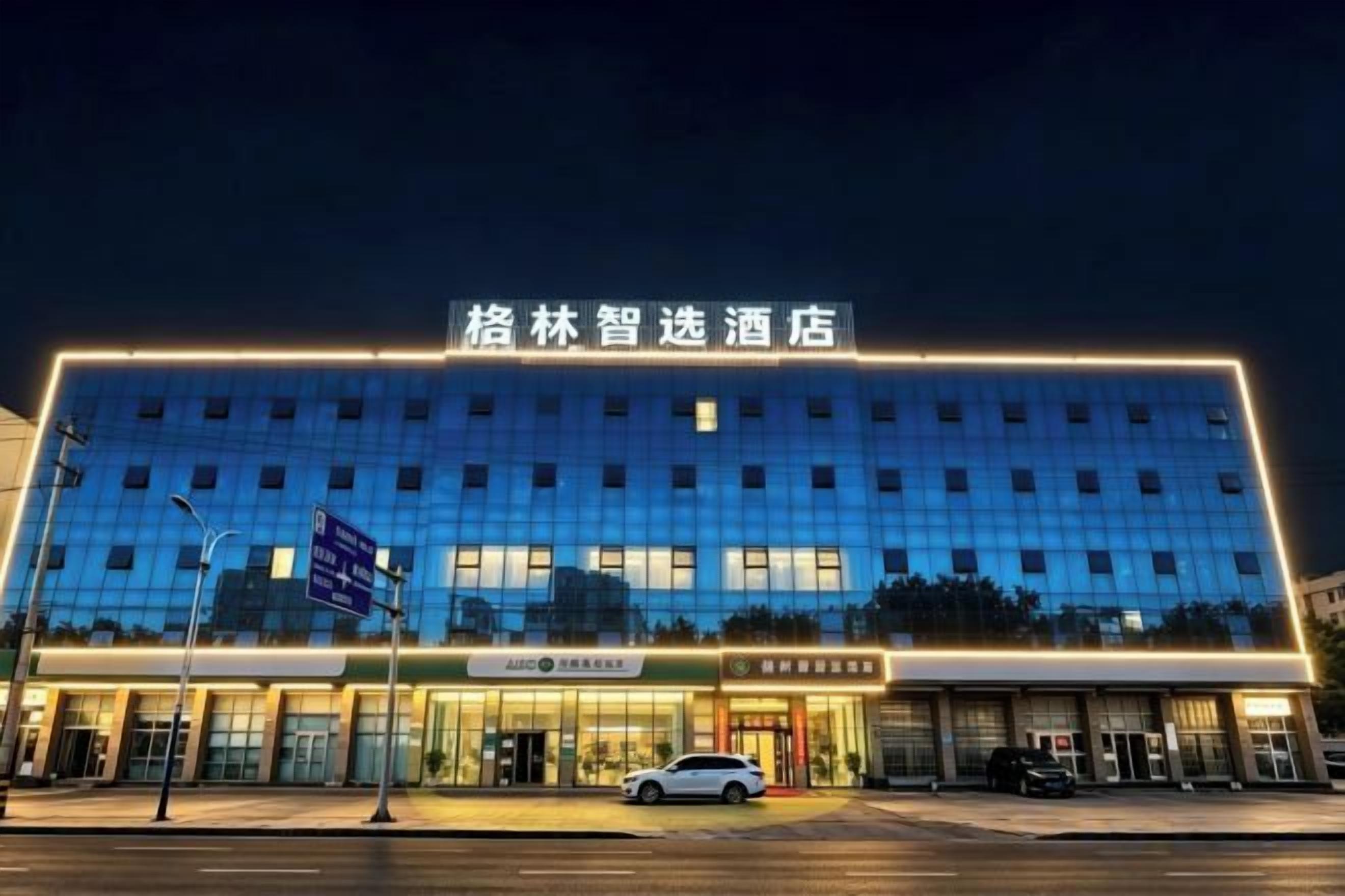 A hotel with a modern facade, multiple entry points, and a well-lit exterior.