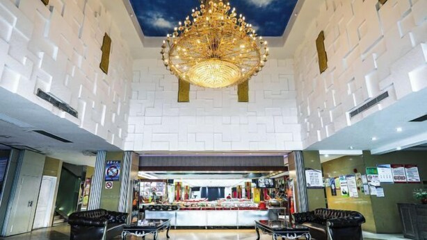 A spacious lobby with a chandelier, seating area, and a food counter. - Jiehui Hotel (Shanghai)