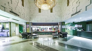 A spacious lobby with a central bar area, two sofas, and a chandelier. - Jiehui Hotel (Shanghai)