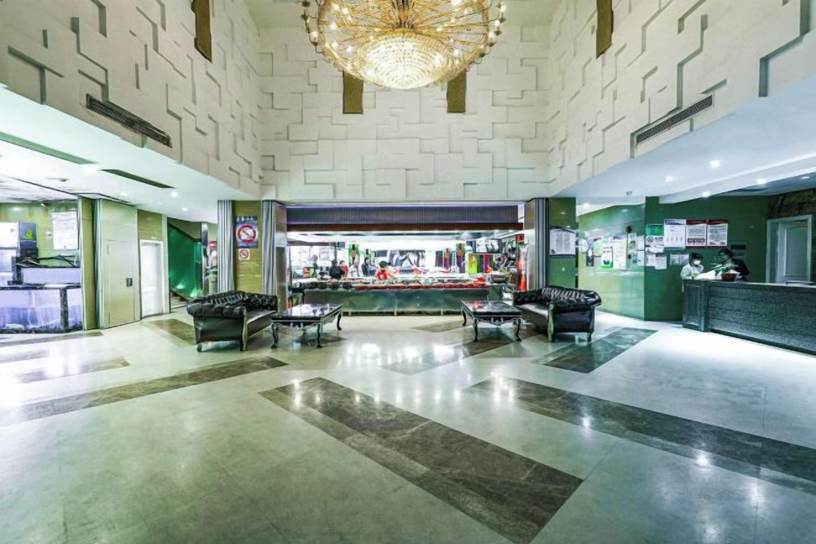 A lobby with a reception desk, seating area, and a chandelier.