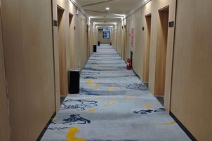 A long hallway with wooden walls and a patterned carpet.