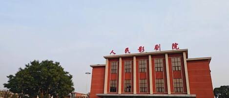 Un edificio rojo con varias ventanas y un cartel sobre la entrada.