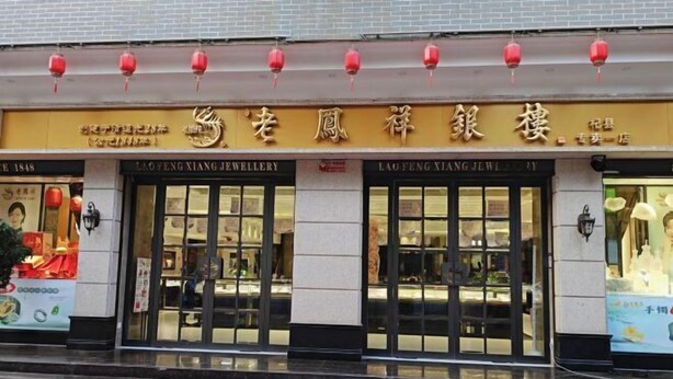 Een etalage met een bord voor Lao Feng Xiang Jewellery.