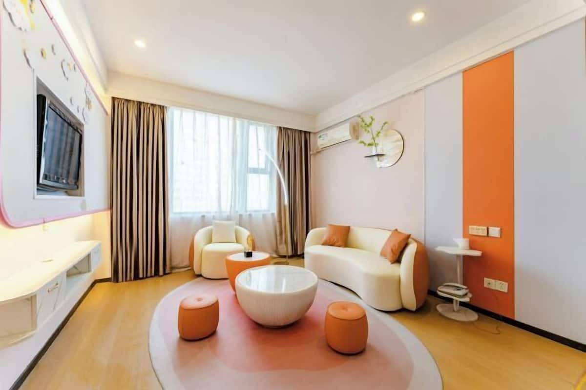 Un salon moderne comprenant un canapé, deux fauteuils, une table basse et un téléviseur.
