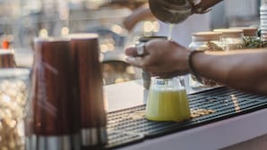 A bar setting with a person pouring a drink into a glass. - Jade Residence (Fethiye)
