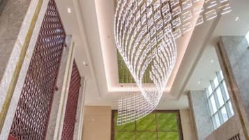 Um interior moderno com luminária de teto diferenciada e área coberta por grama sintética verde.