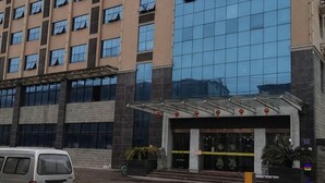 A hotel entrance with a modern glass facade, a covered entrance area, and a parking lot. - Fuzhou Ningyu Hotel (Fuzhou)