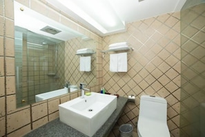 A bathroom with a large mirror, a white sink, a toilet, and a glass shower enclosure. - Minghao Hotel (Xianju)