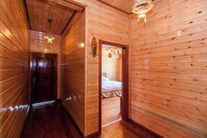 A wooden hallway leading to a room with a bed. - Luyuan Villa (Yixing)