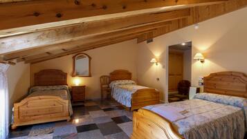 Une chambre à coucher avec deux lits en bois, une chaise en bois, une table de chevet et un miroir.