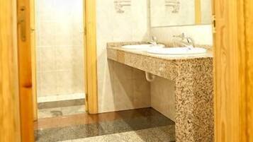 Un baño con dos lavamanos, un espejo y piso de baldosas.