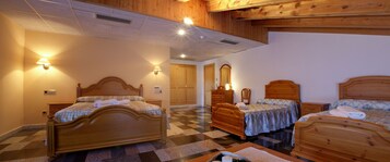 Quarto de hotel com três camas de madeira, chão xadrez e vigas de madeira no teto.