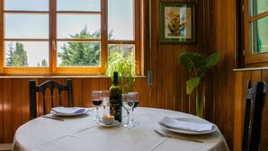 A dining table set with wine glasses, plates, and a bottle of wine. - Hostal Casa Ramón III (Quintanar de la Sierra)