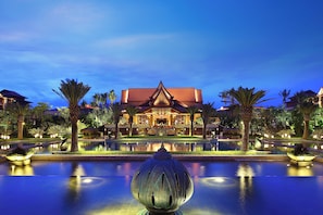 A large building with a traditional architectural style, surrounded by a well-maintained garden and a reflective pool. - Crowne Plaza Resort Xishuangbanna Parkview by IHG (Xishuangbanna Dai)