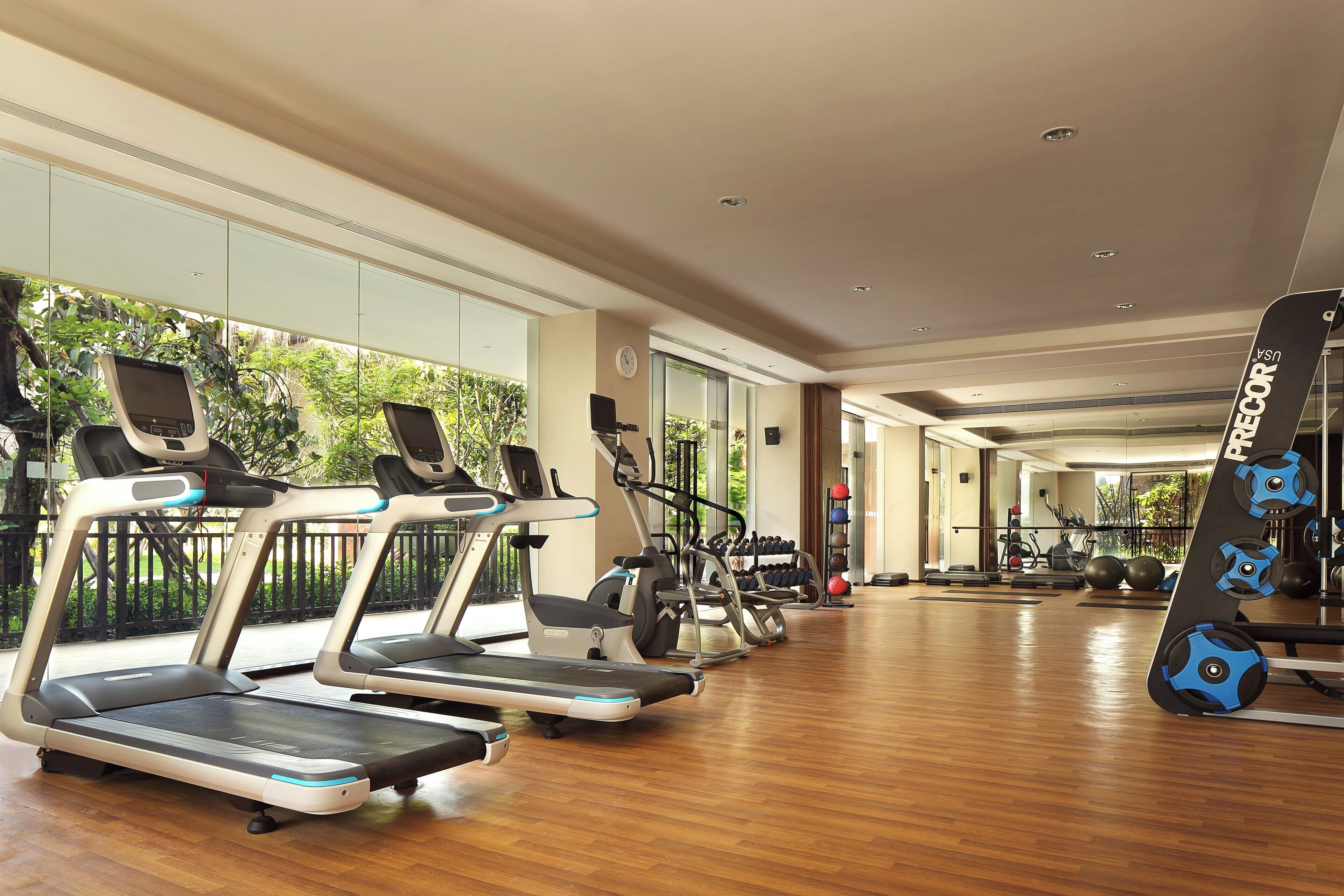 A gym with treadmills, exercise bikes, and weight equipment.