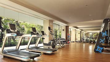A gym with treadmills, exercise bikes, and weight equipment.