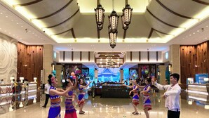 A spacious lobby with a modern chandelier, a reception desk, and a decorative wall with vertical patterns. - Crowne Plaza Resort Xishuangbanna Parkview by IHG (Xishuangbanna Dai)