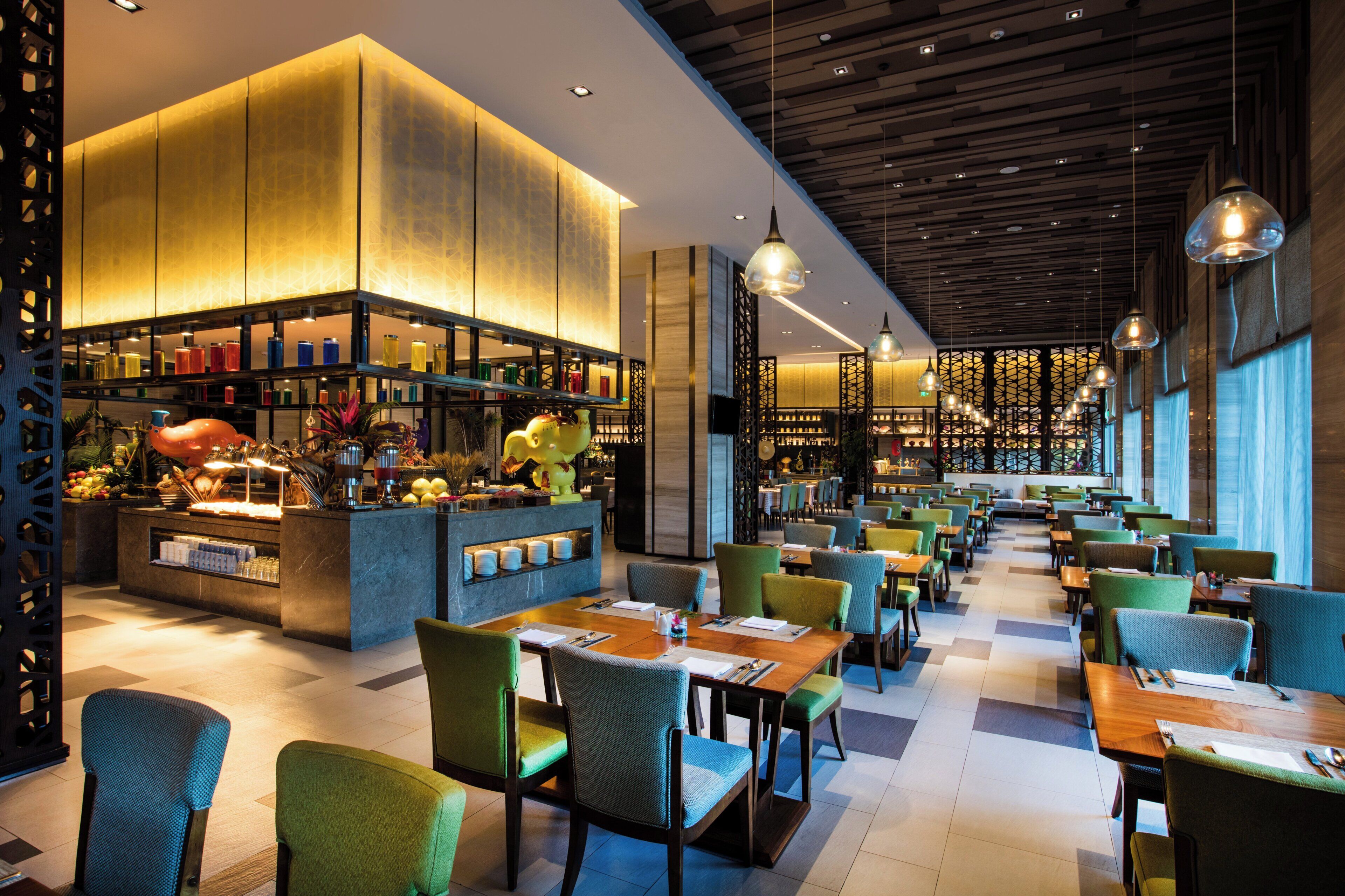 A modern restaurant with a bar area, multiple seating options, and a variety of table settings.