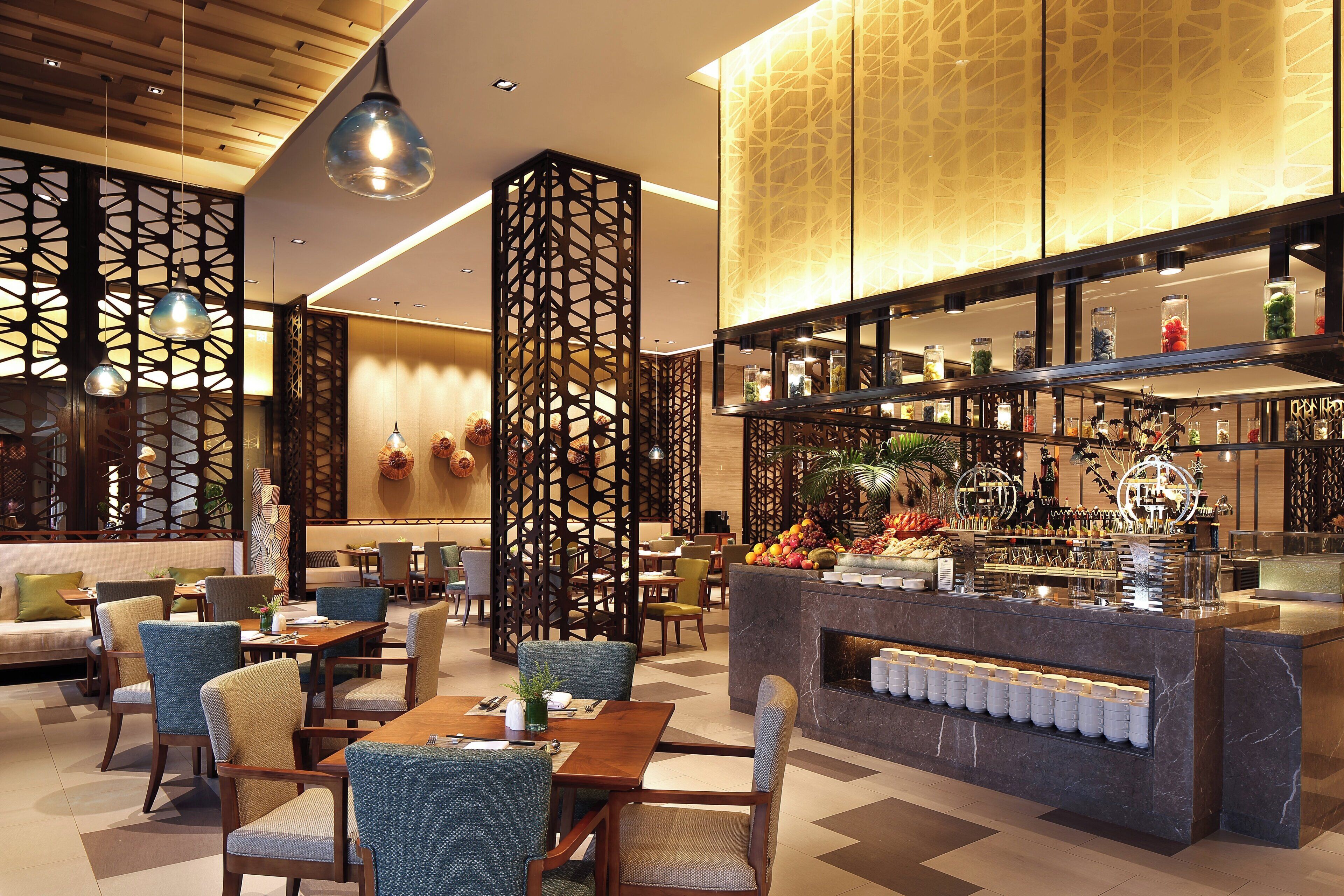 Een moderne hotelentree met zitgedeeltes, een bar en decoratieve elementen.