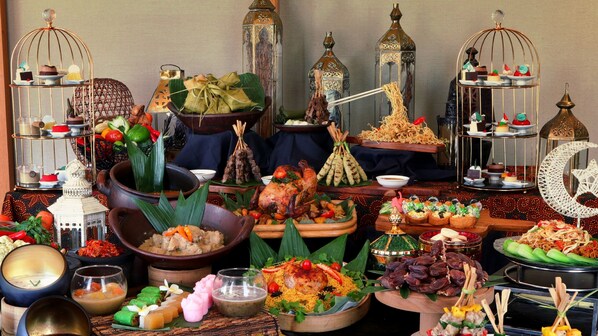 Une variété de plats et d’aliments sont présentés sur une table, notamment un poulet rôti, du riz et divers desserts.